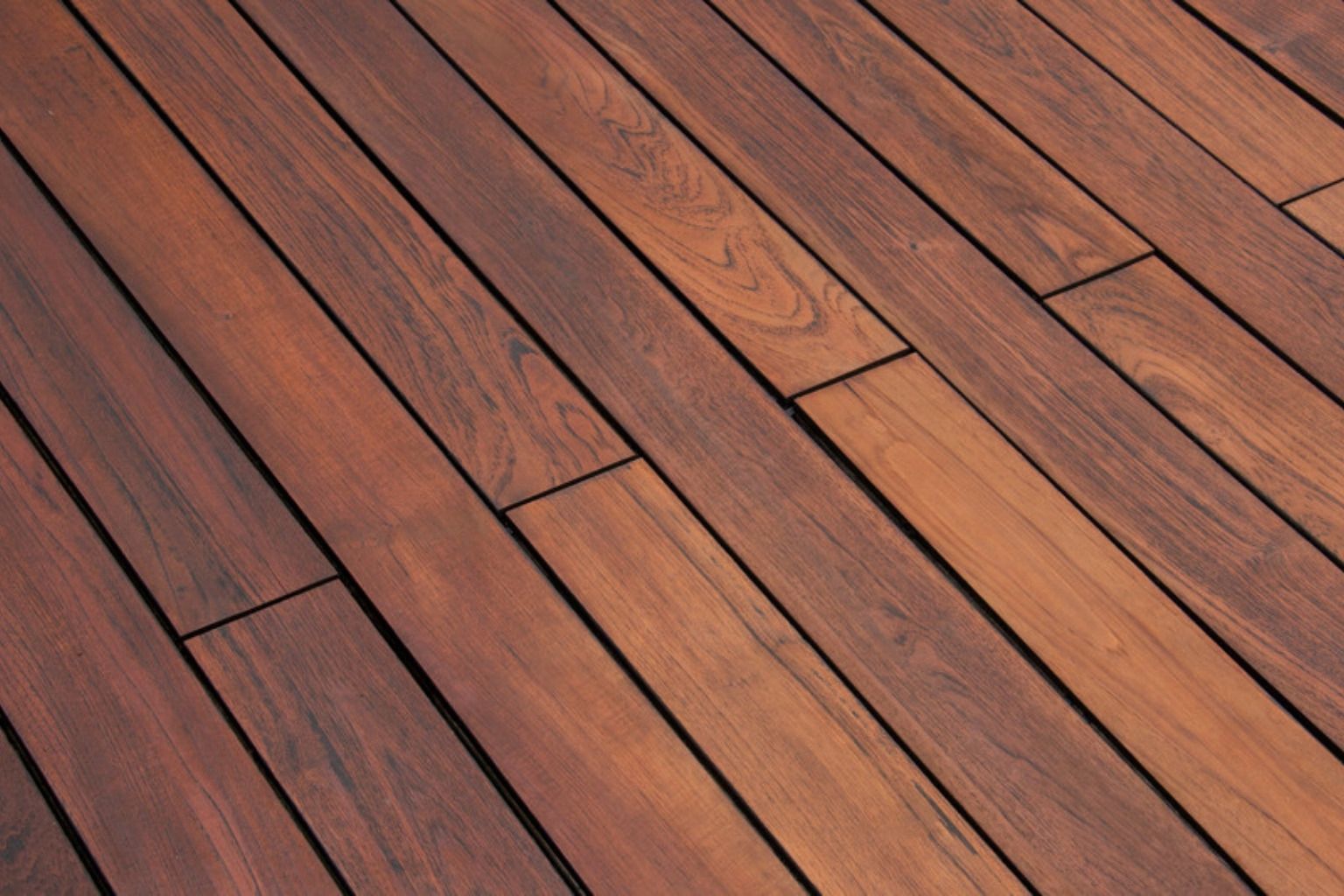Mørkebrune, varmebehandlede terrassebrædder lagt diagonalt med synlige skruer